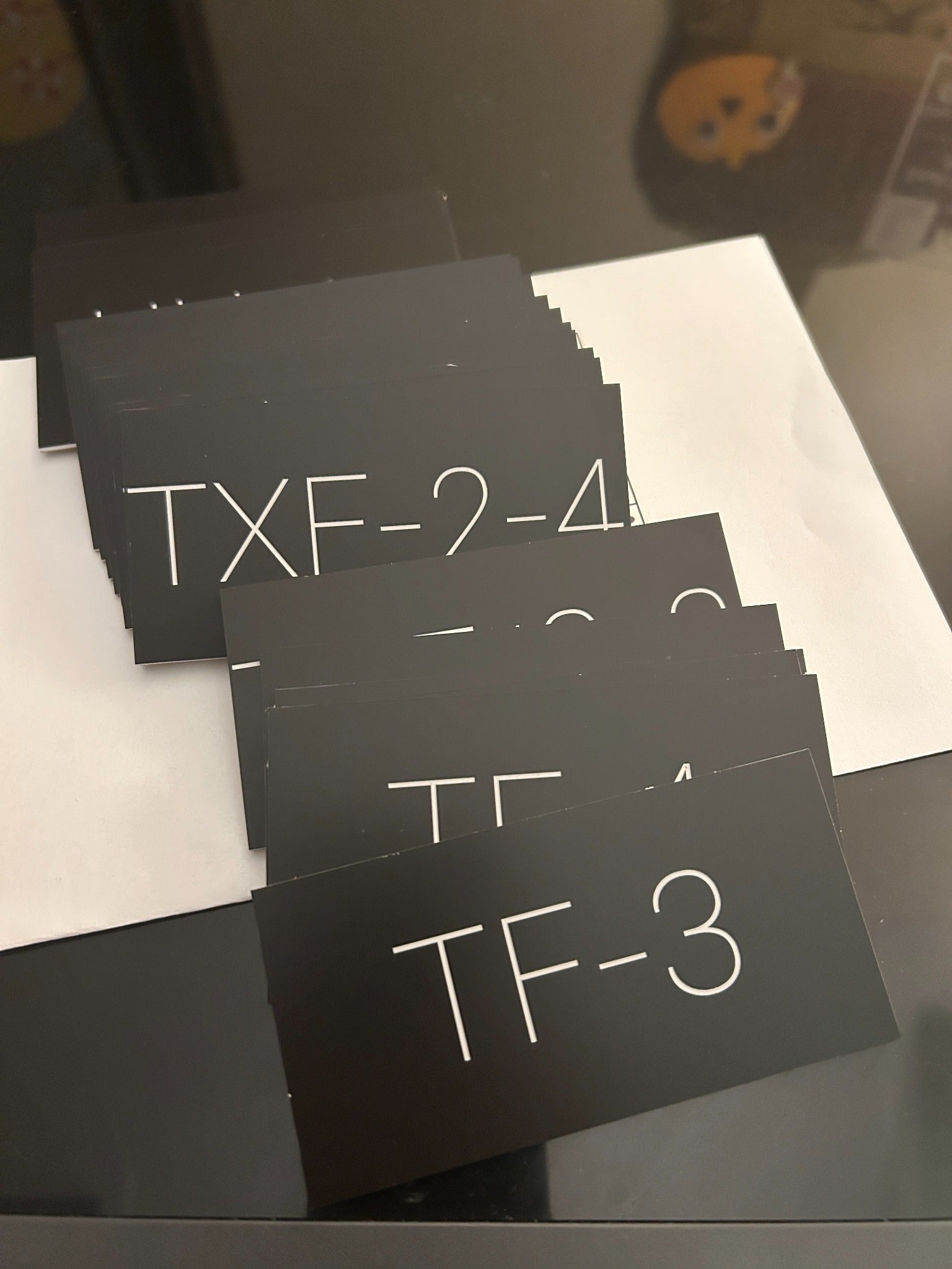 Stacks of engraved black acrylic equipment identification tags